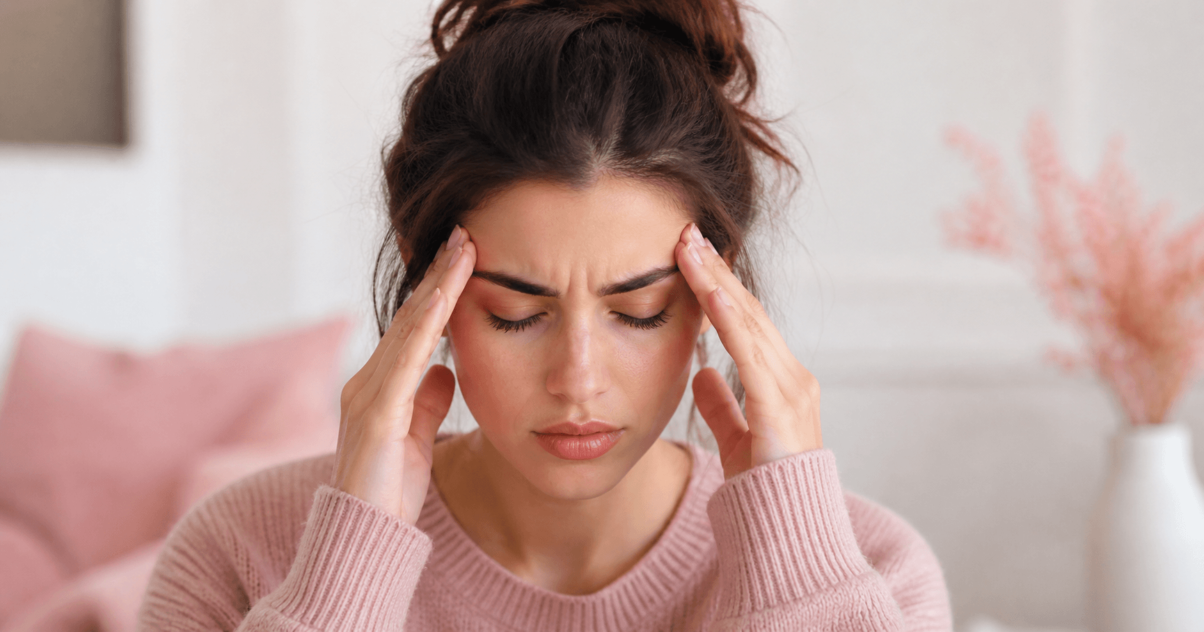 Woman pressing her temples with a headache before her period — illustrated
